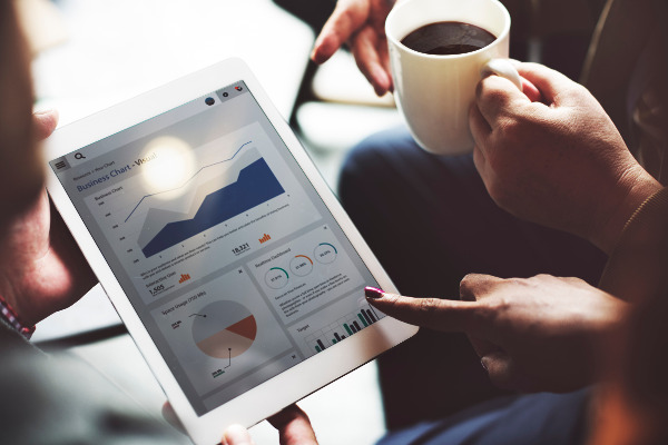 Business People looking at charts while drinking coffee
